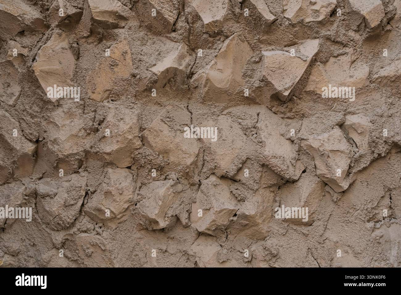 Authentic Middle Eastern stone wall texture with handmade plaster and natural rock elements. Warm neutral background  Stock Photo