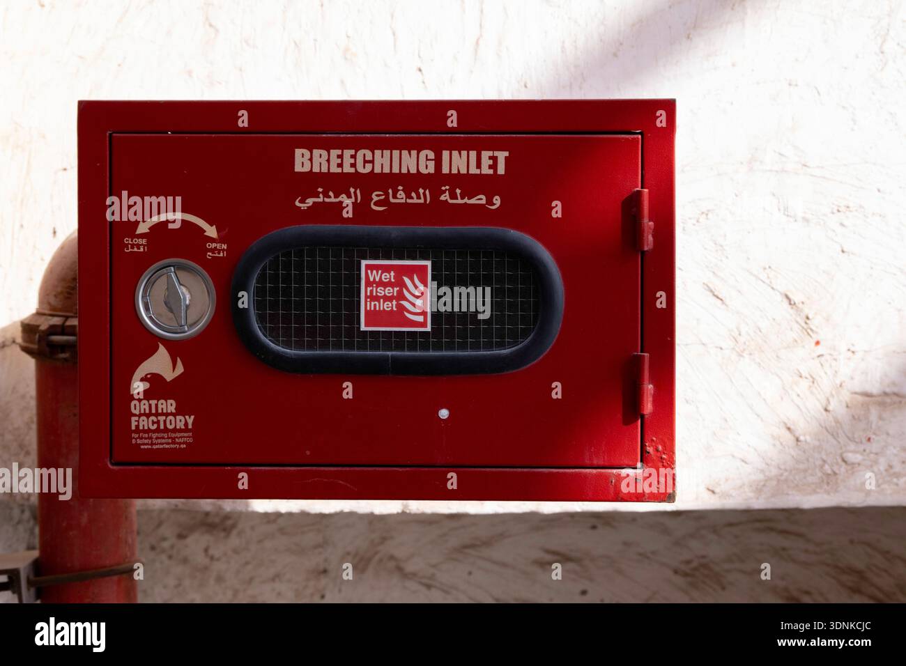 Doha, Qatar - January 25, 2026: Red fire nozzle box mounted on wall with glass front panel, containing fire hose reel for emergency use Stock Photo