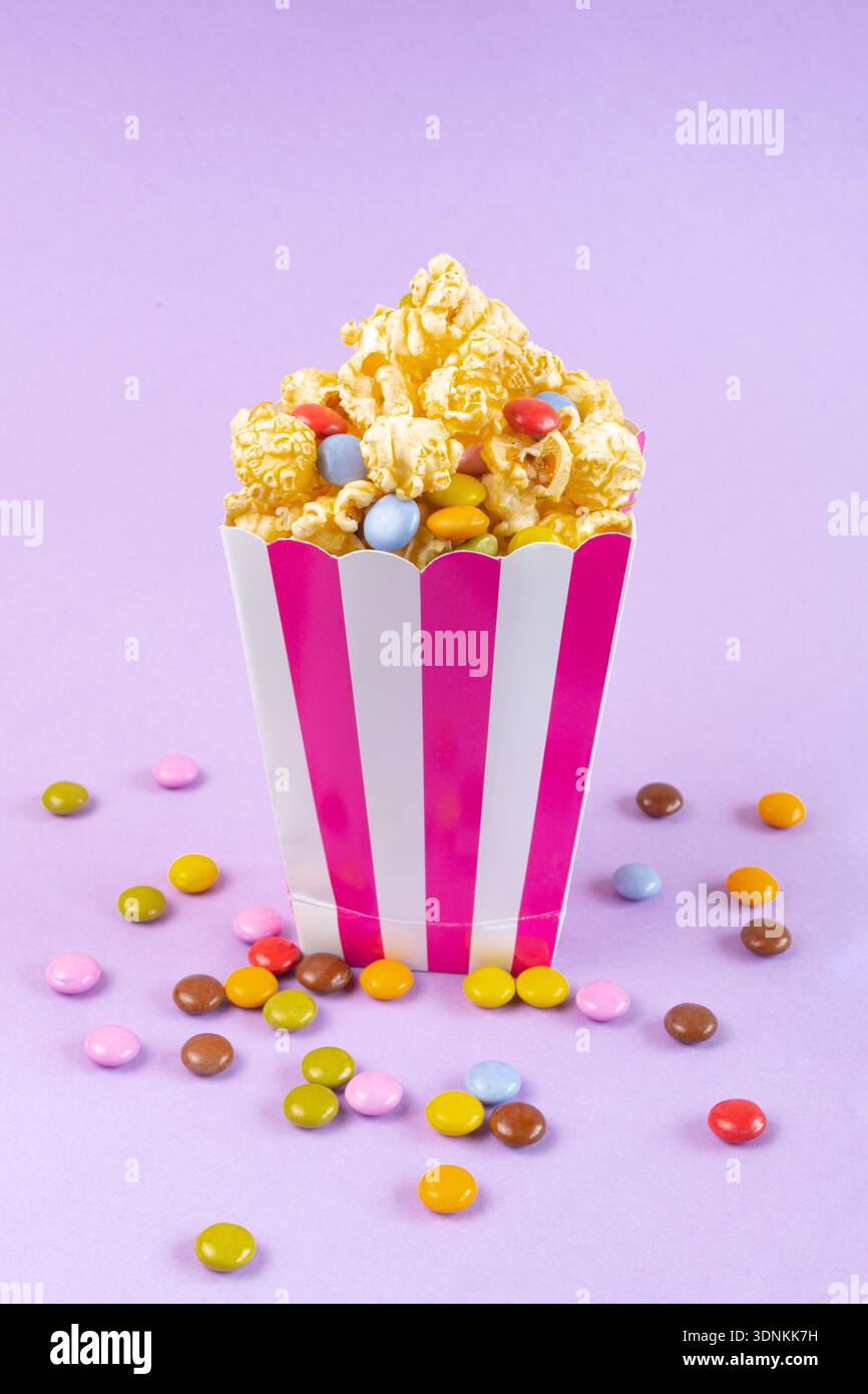 sweet popcorn with dragee on purple background Stock Photo