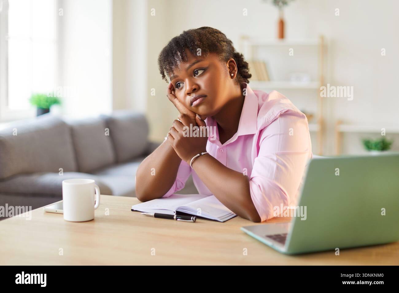 Tired Or Bored African American Woman Working On A Laptop At Home Stock Photo