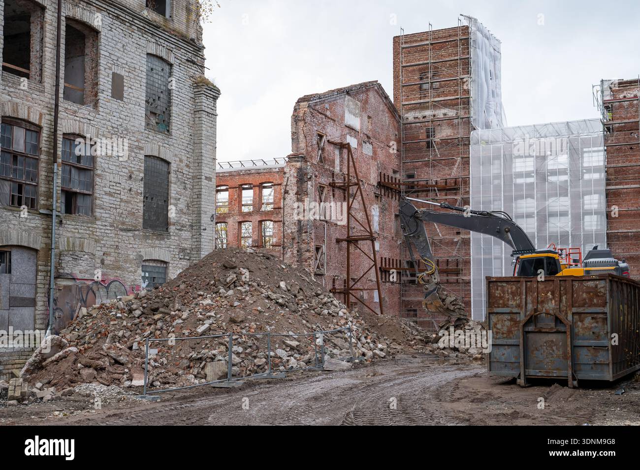 Rubble Standing Excavator with demolition attachment breaks apart building while ...