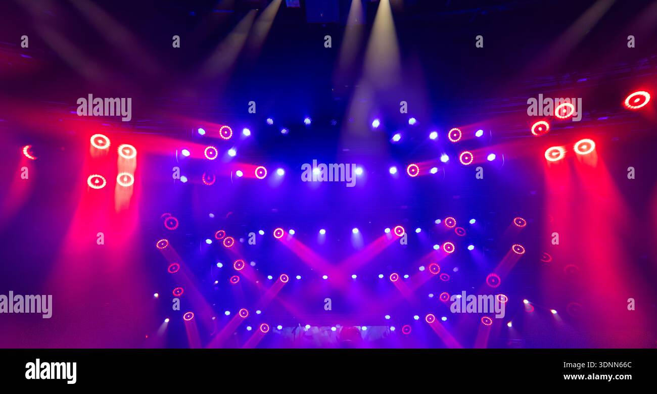 Dynamic Stage Lighting with Red and Blue Beams During Live Concert Performance Stock Photo