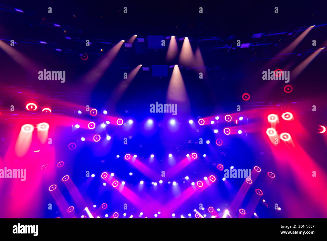 Dynamic Stage Lighting with Red and Blue Beams During Live Concert Performance Stock Photo