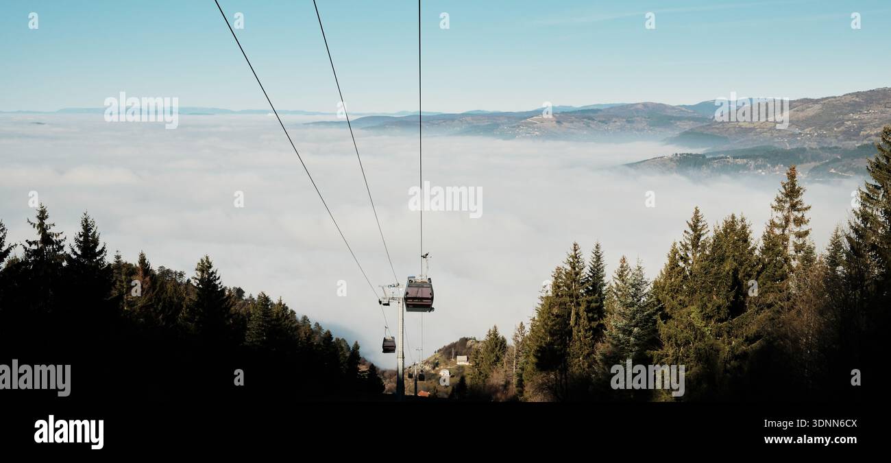 Cable car rising above a sea of clouds on Trebevic mountain in Bosnia ...