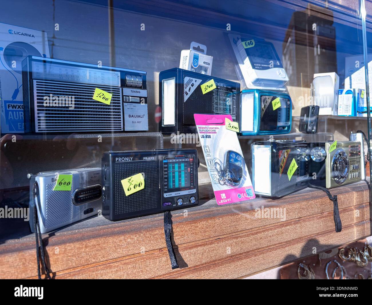 Portable transistor radios, receivers, and small gadgets displayed in a shop window in Naples, Italy. Secondhand electronics and bargain hunting at a Stock Photo