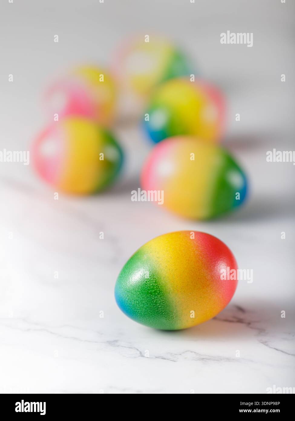 Painted natural easter eggs on a light marble background. One egg closeup Stock Photo
