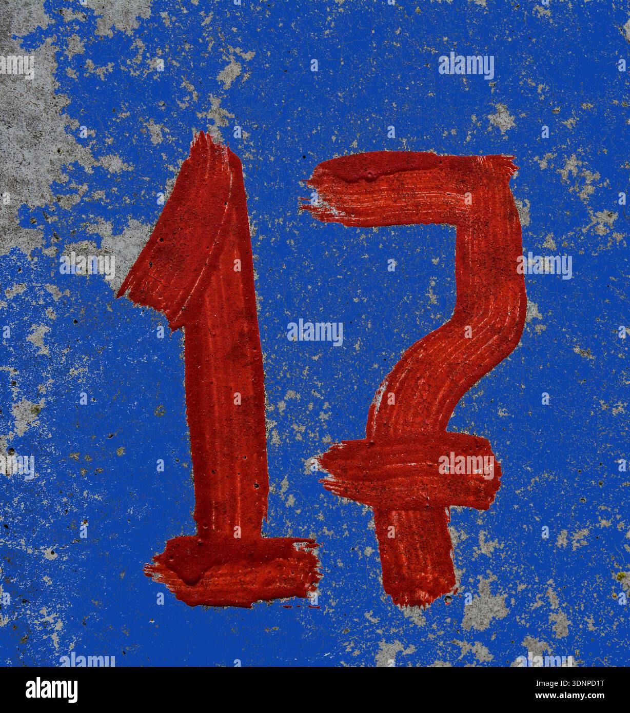 Parking number 17 with screen paint on concrete.red number 17 is written with a brush on concrete. Stock Photo
