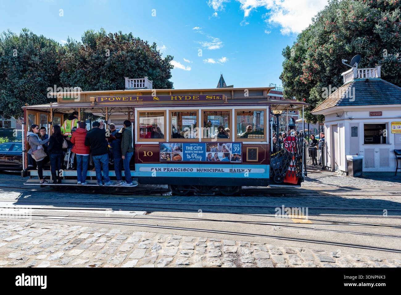 Traditional red and yellow cable car moving through San Francisco ...
