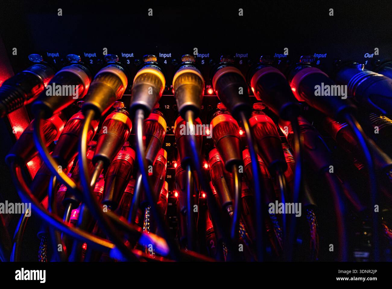 Professional Audio XLR Connectors and Cables with Red Indicators on Patch Panel Stock Photo