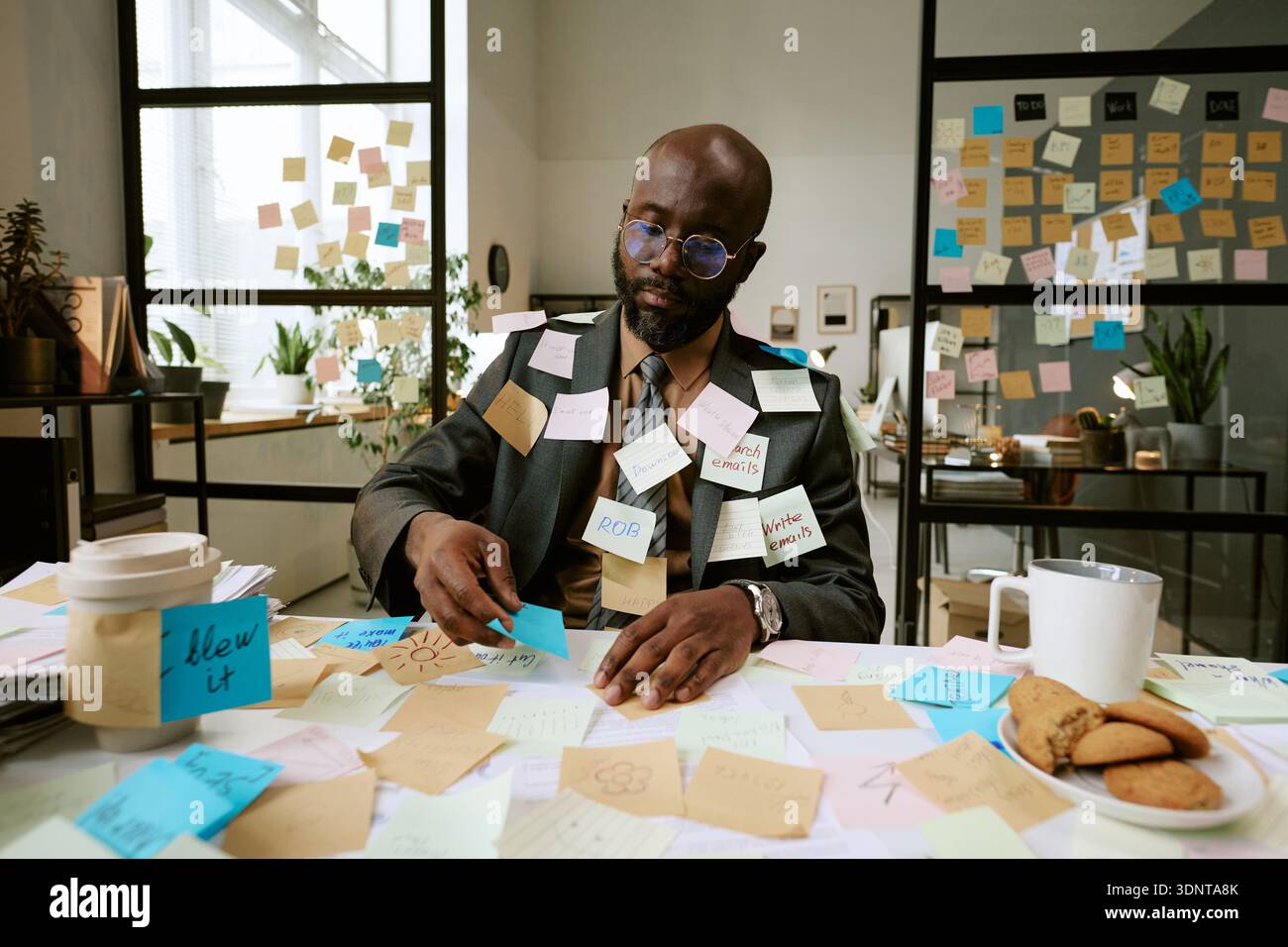 Black Man Organizing Sticky Notes during Busy Business Planning Stock Photo
