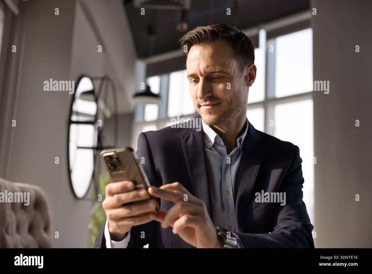 Positive handsome Hispanic CEO man using online business application Stock Photo