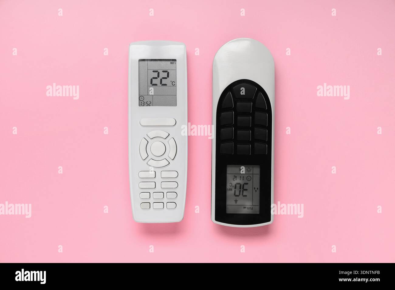 Air conditioner remote controls on pink background Stock Photo