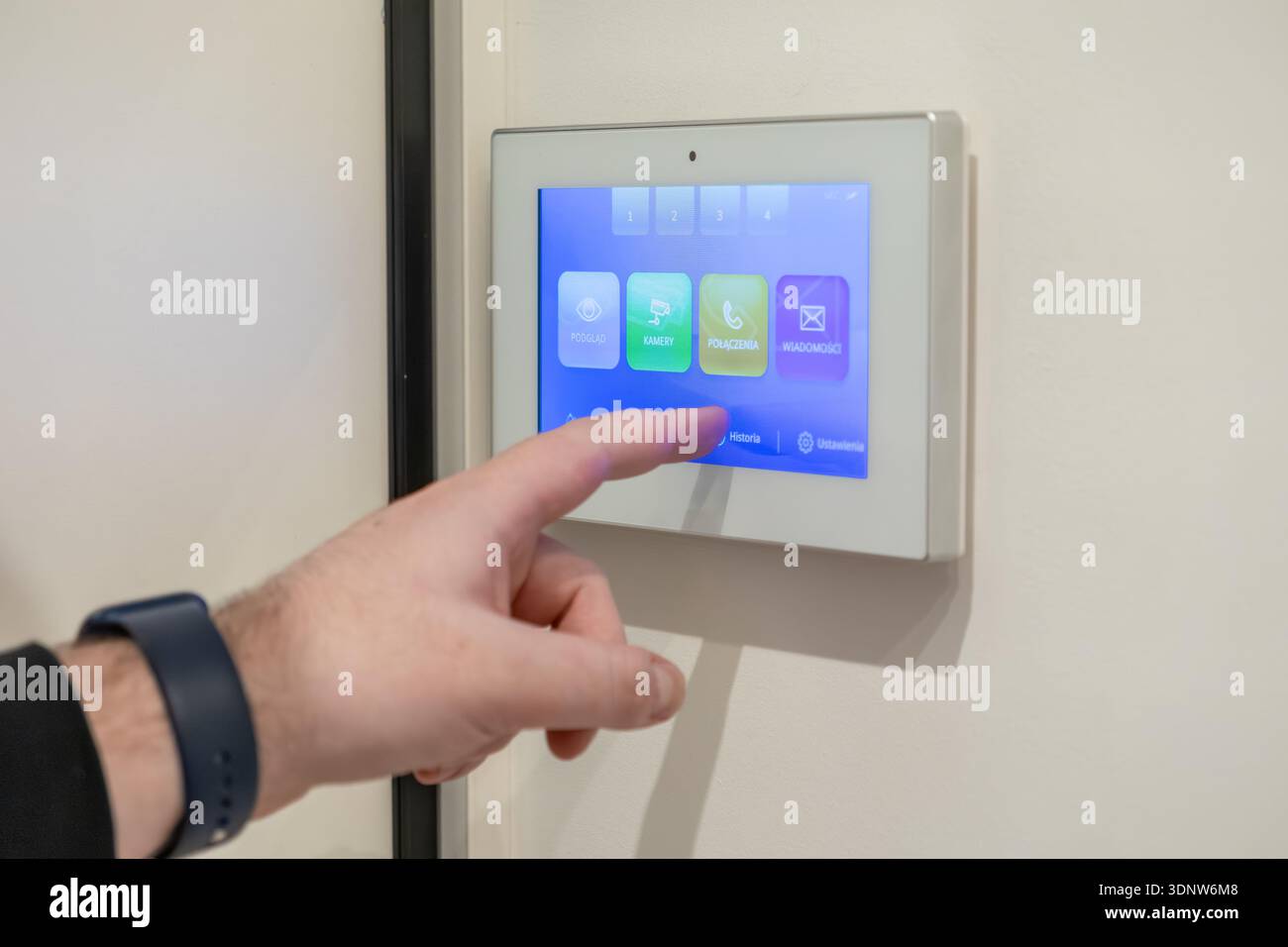 Top view of a person using a smart home video door phone, navigating its interactive screen for comprehensive residential security and communication s Stock Photo