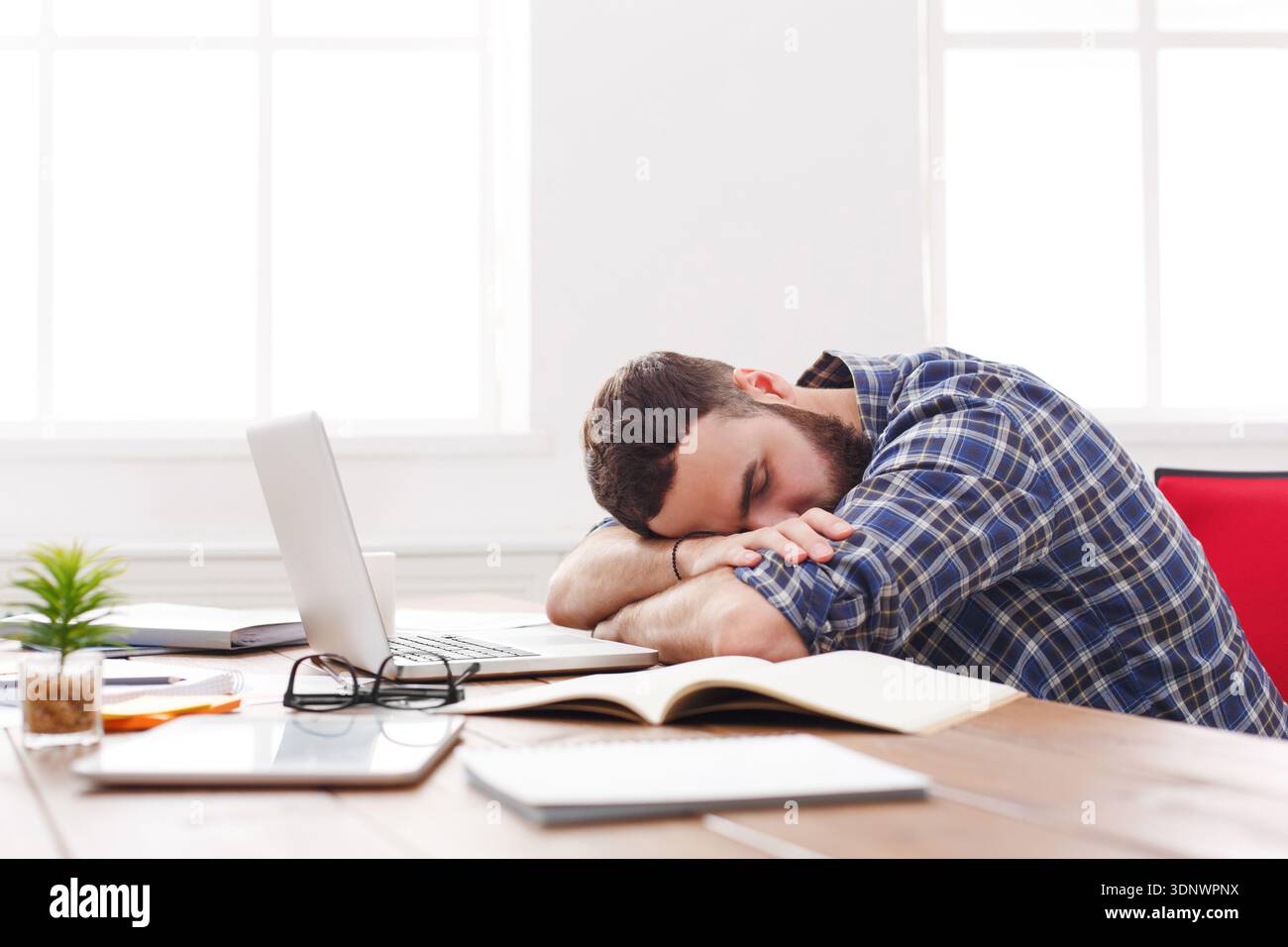 Overworked exhausted manager sleeping on table after working day Stock Photo
