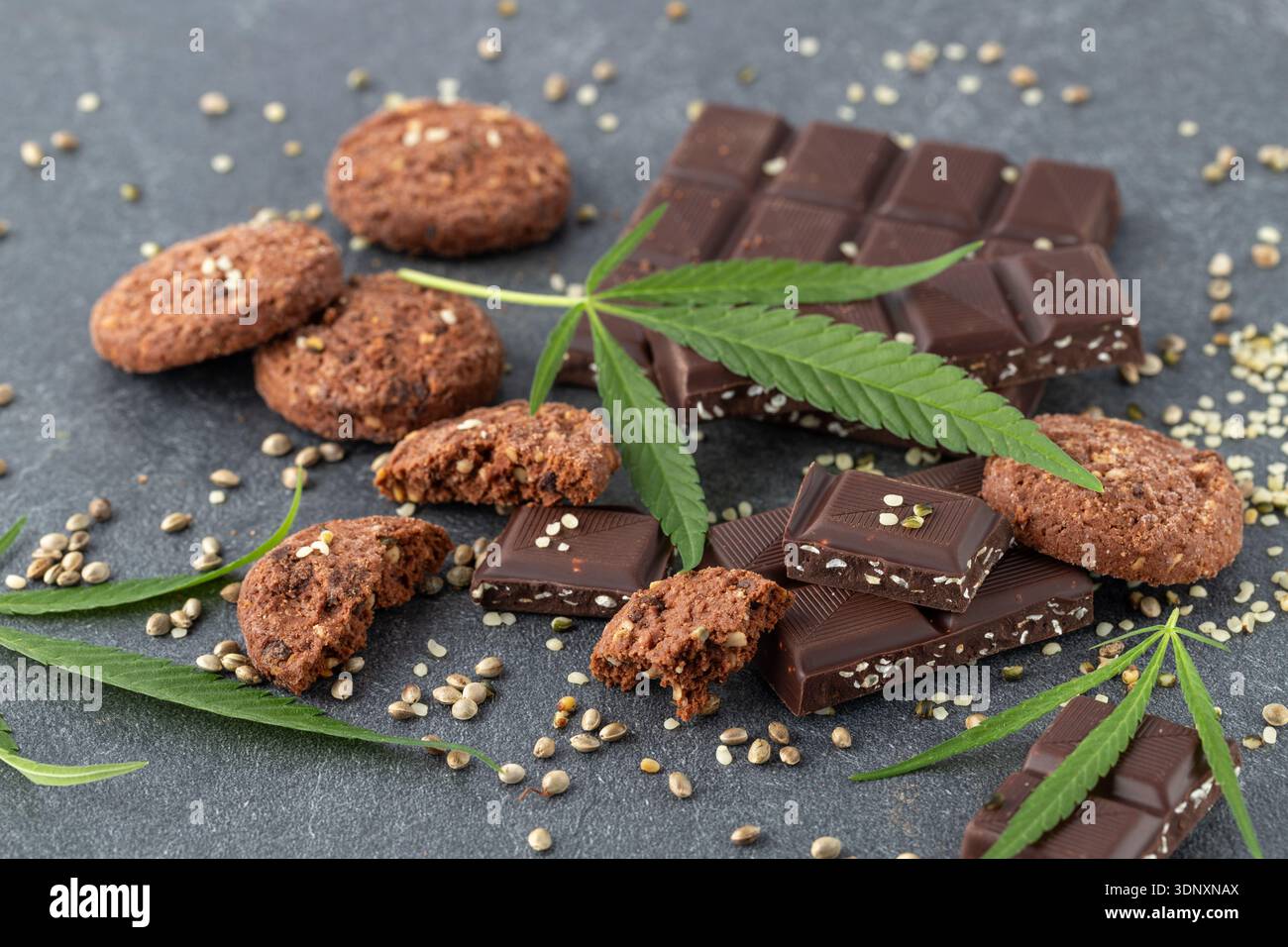 Broken dark chocolate bar with infused crushed hemp seeds on stone  background. Vegan chocolate pieces and cannabis leaf and seeds closeup on  dark tabl Stock Photo - Alamy