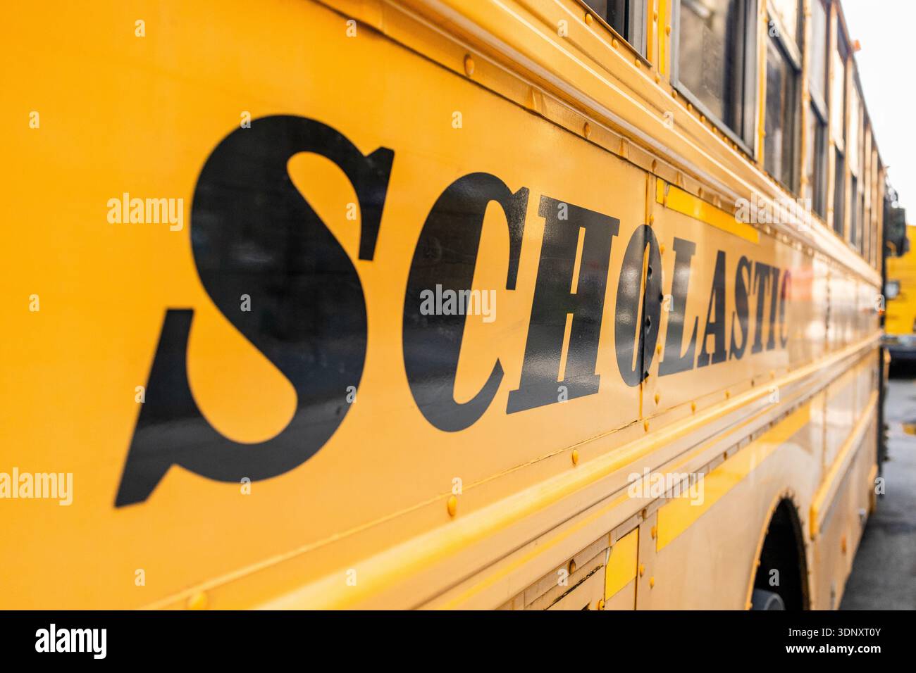 A close-up shot of a yellow school bus exterior with bold, black ...