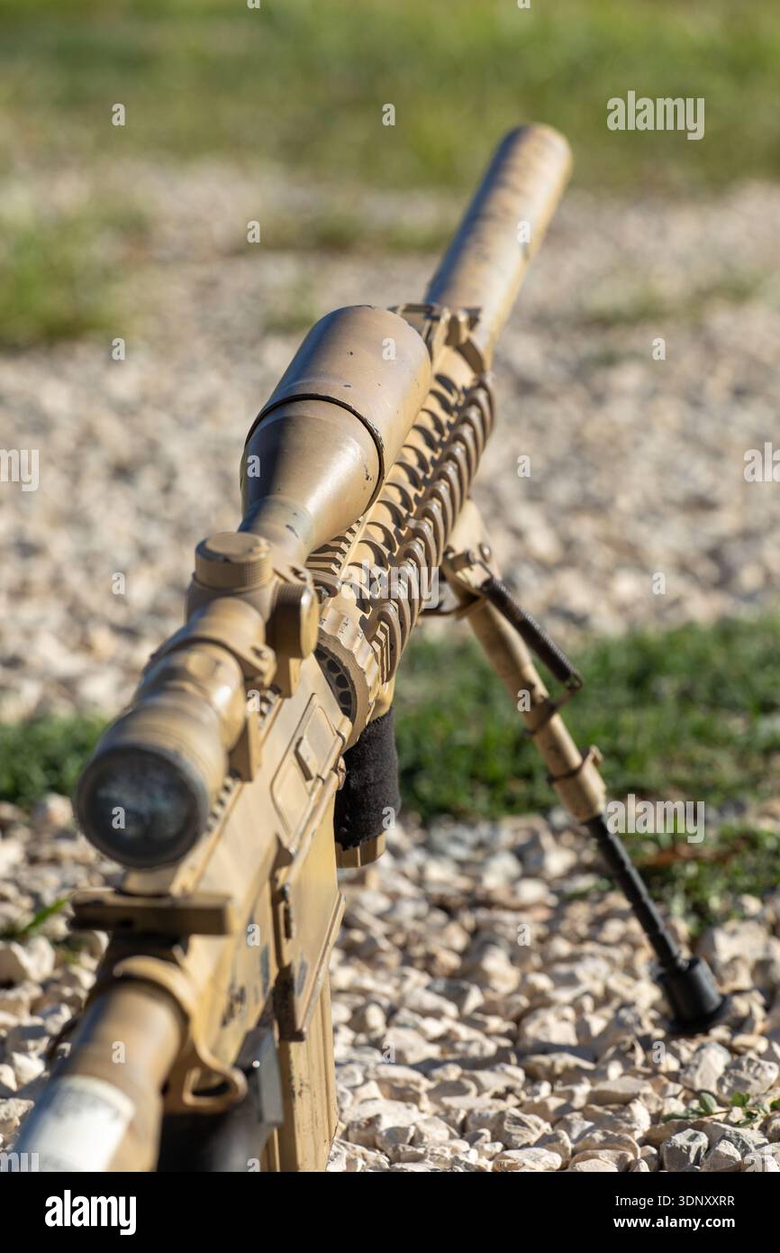 A detailed close-up of an airsoft sniper rifle with desert camouflage ...