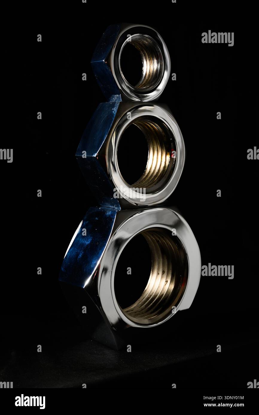 Large industrial nuts stacked with a dark background Stock Photo