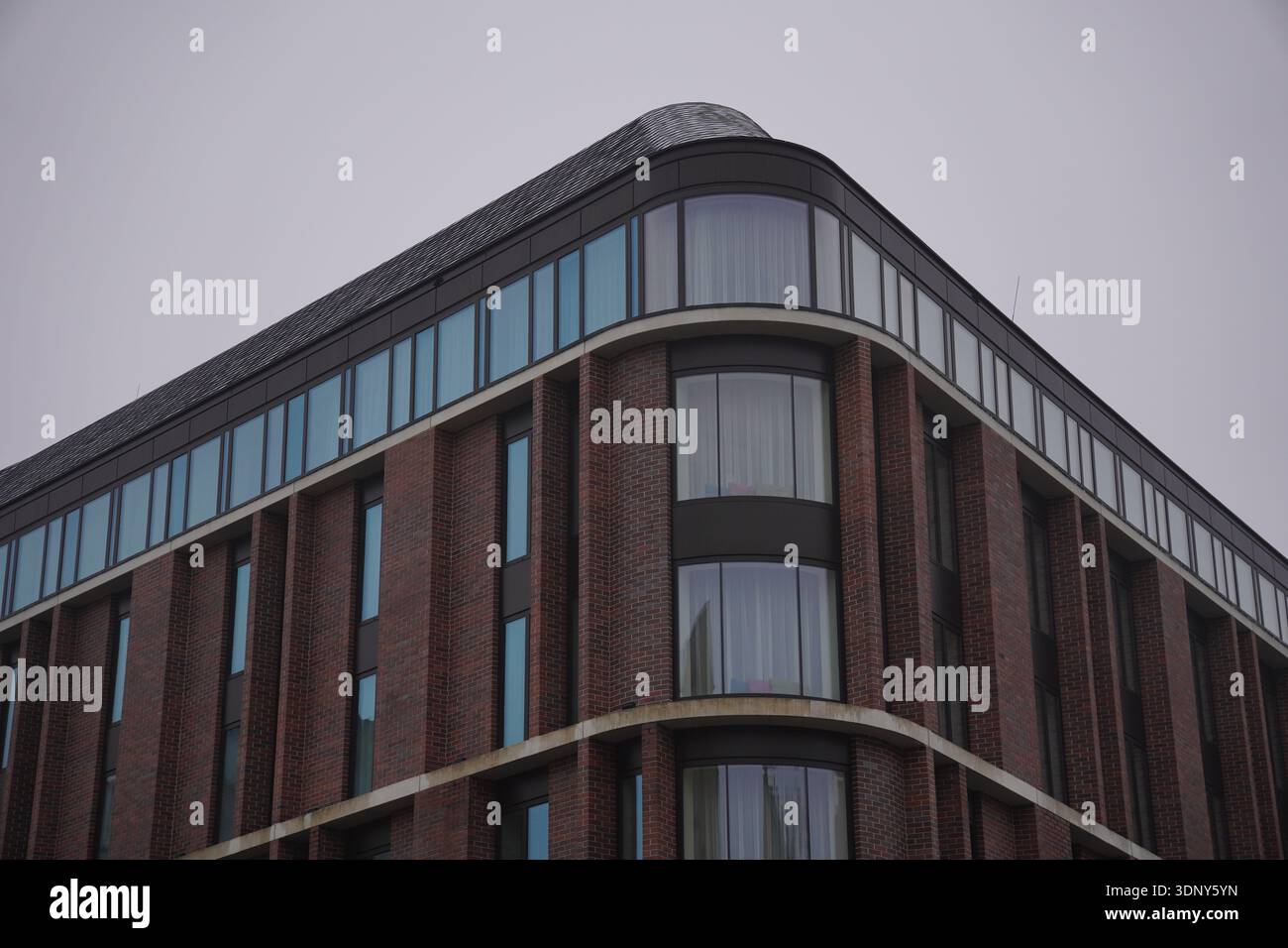 Red Rounded Buildings Modern residential building with distinctive curved corner tower, red ...