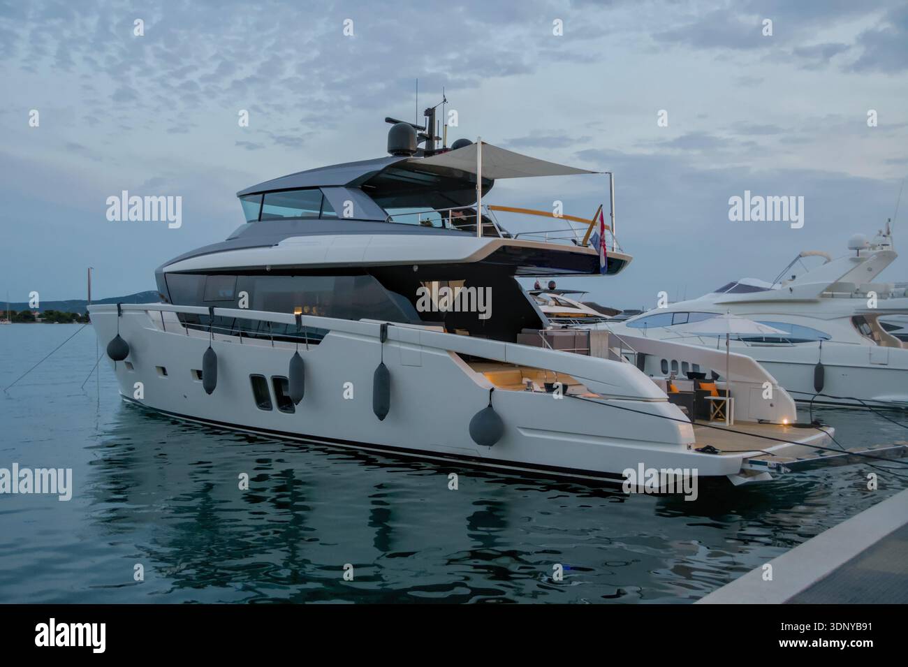 Elegant white motor yacht with sun awning on the top deck Stock Photo ...