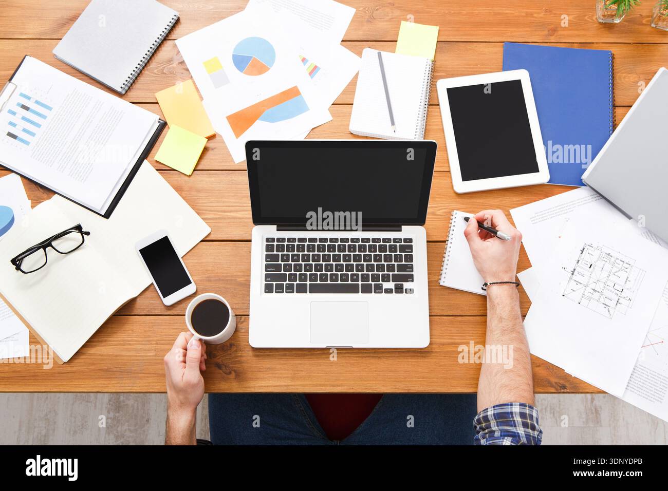 Top view businessman using laptop with analyzing investment charts on the office desk. Stock Photo