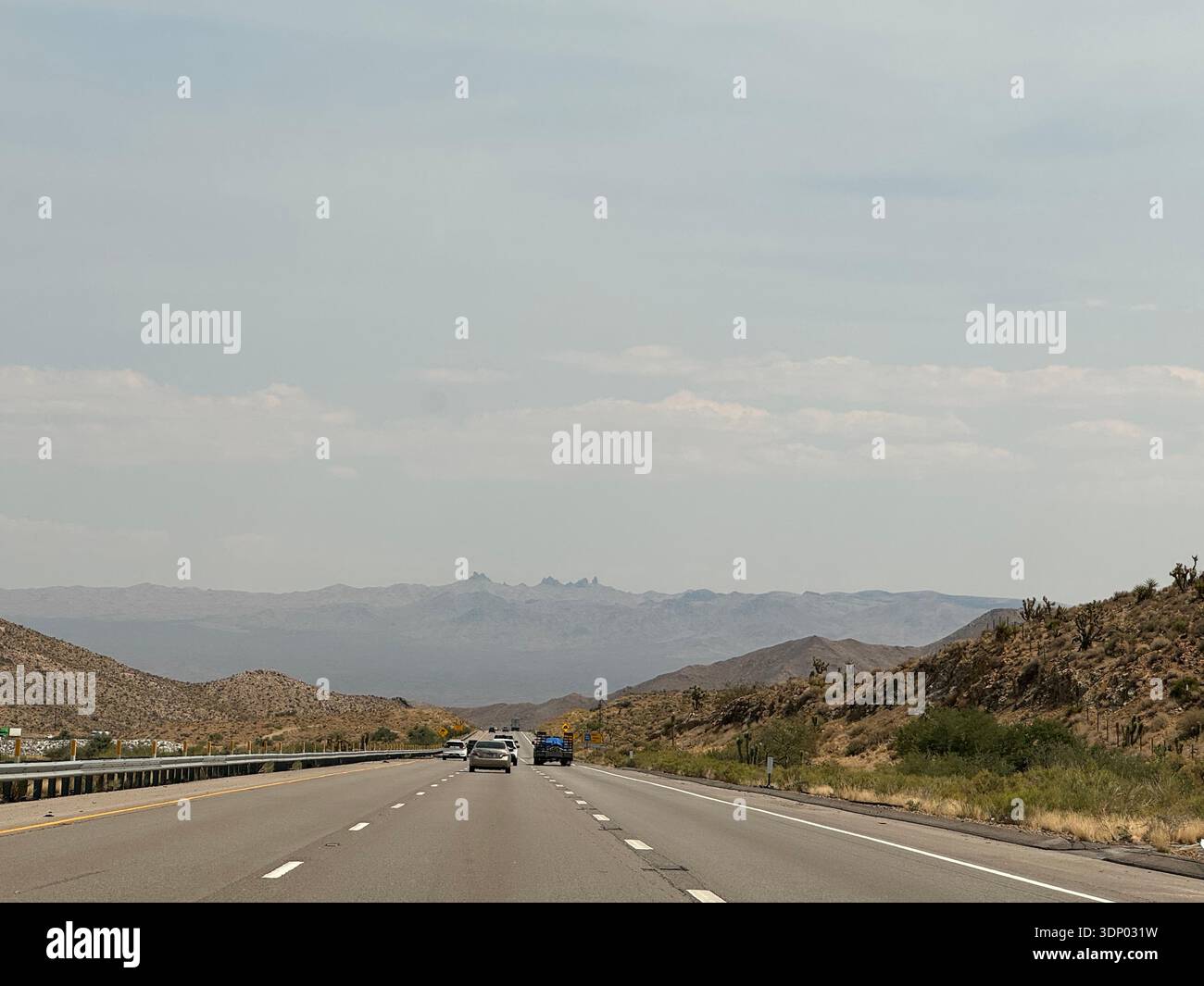 Highway stretching through desert landscape with distant mountains in the American Southwest, USA. - Smartphone Captured Stock Image