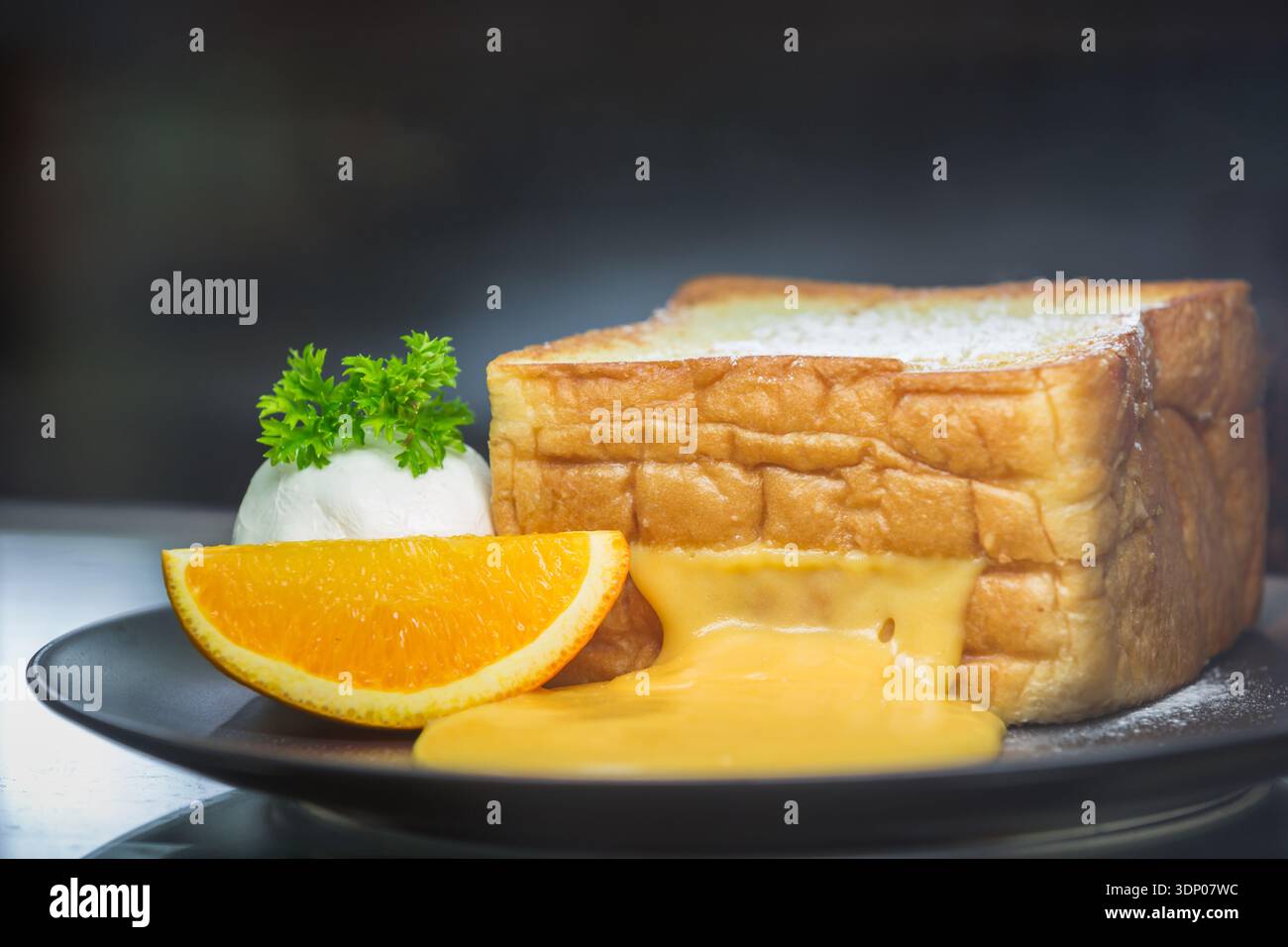 orange toast with icecream on black dish Stock Photo