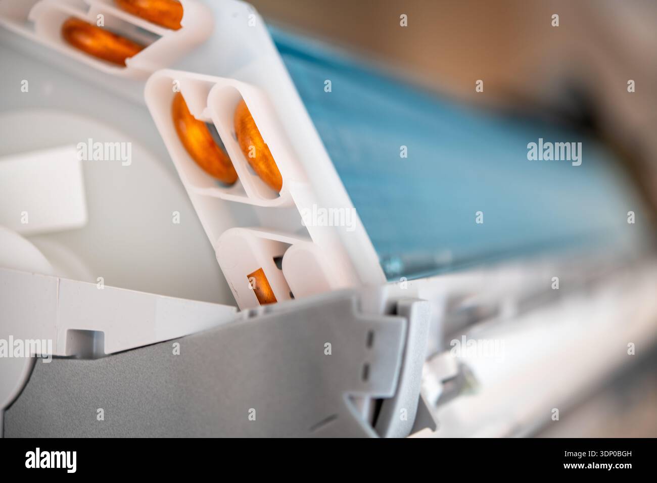 Closeup view of the internal components of a domestic air conditioner showing the heat exchanger fins and plastic housing parts. Stock Photo