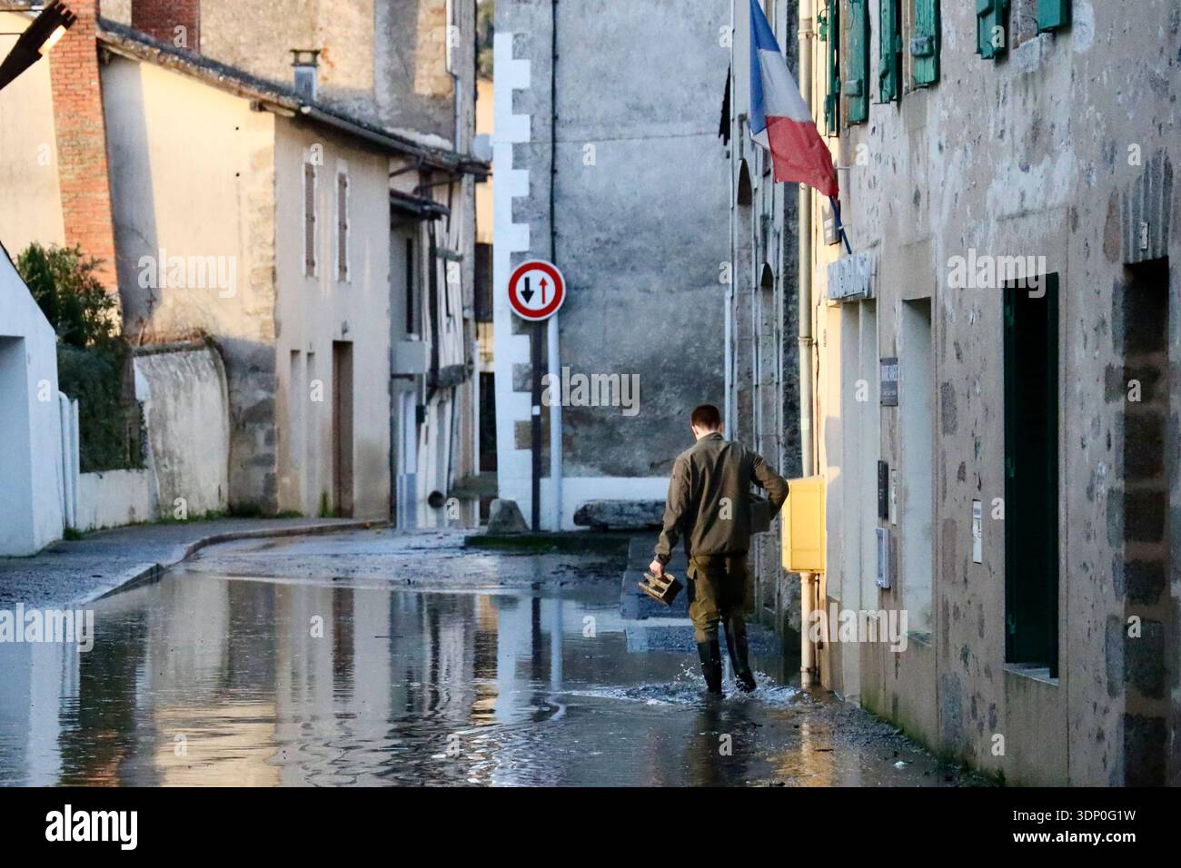 A man walks along a flooded street of Saint-Germain de Confolens as ...