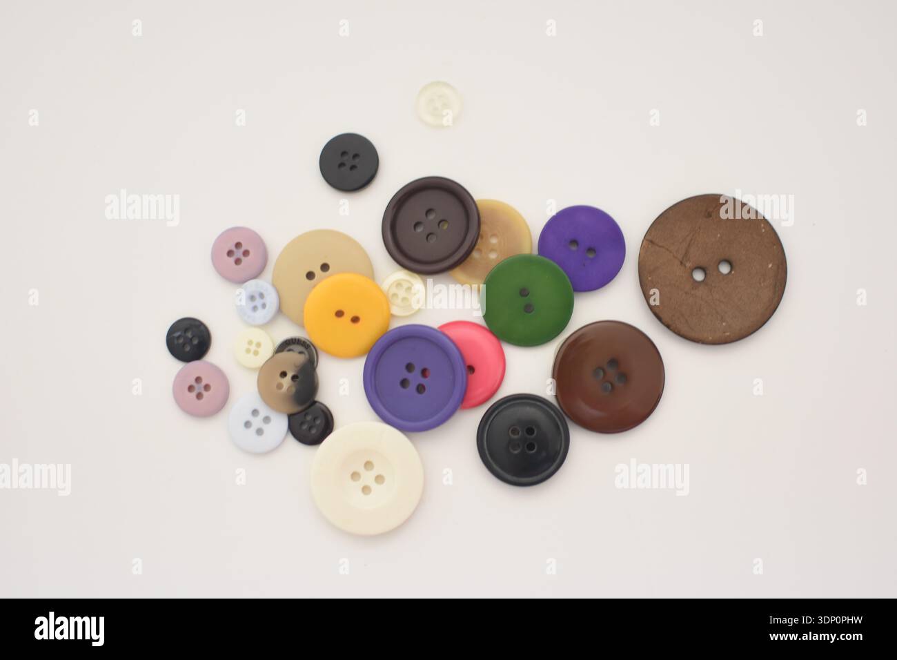 Colorful Buttons Scattered on White Table, Top View Flat Lay Stock Photo