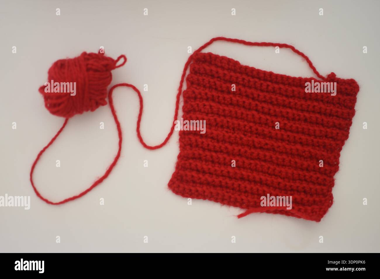 Red Crochet Yarn Piece on White Table, Top View Flat Lay Stock Photo