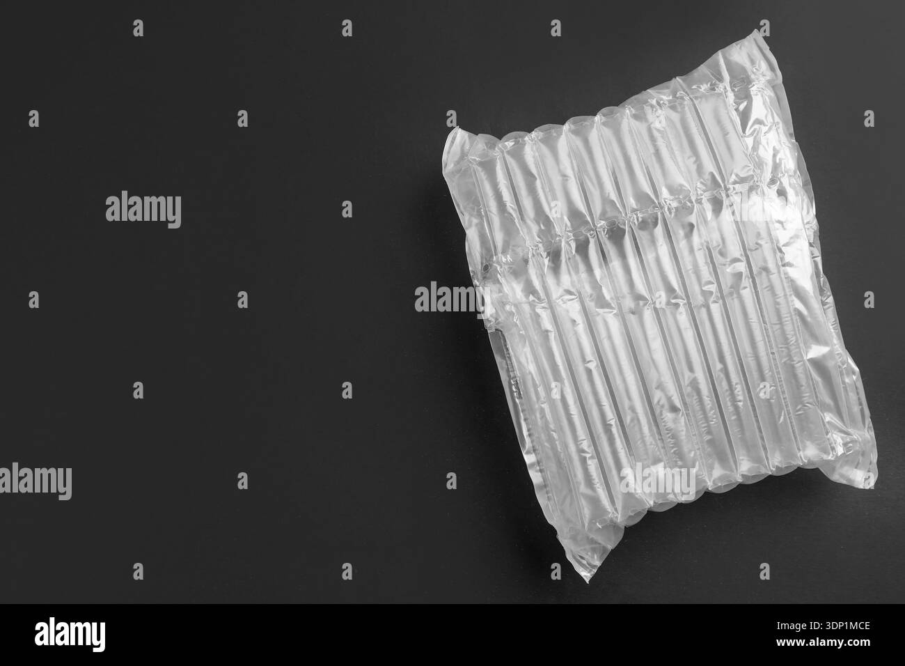 Transparent air buffer packaging on black background, top view. Space for text Stock Photo