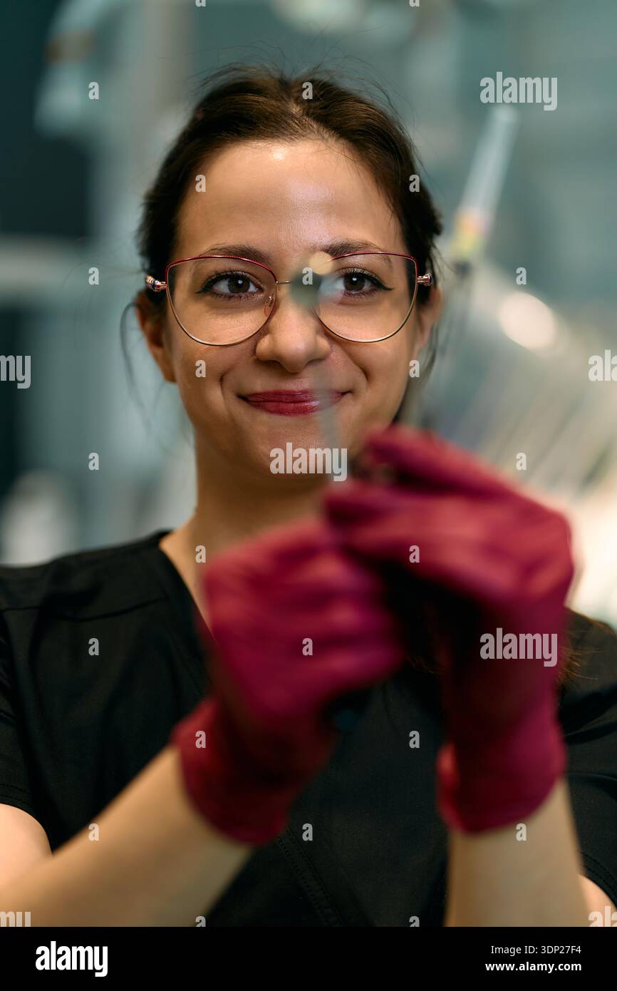 Lab Technician With Pink Gloves Holding Test Tube In Modern Laboratory Setting During Analysis Stock Photo