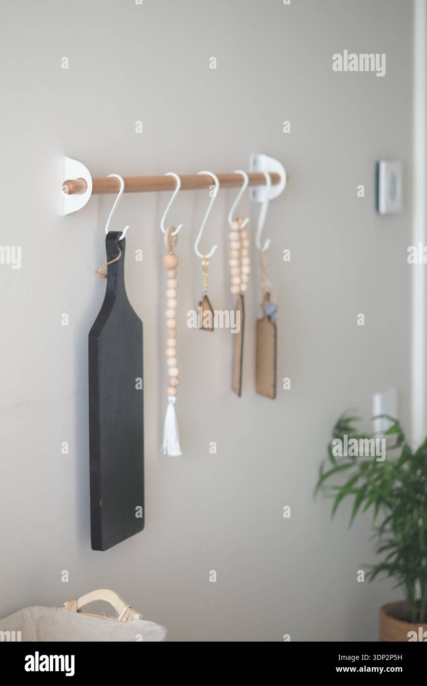 Kitchen items are arranged on a wall rack in a home Stock Photo