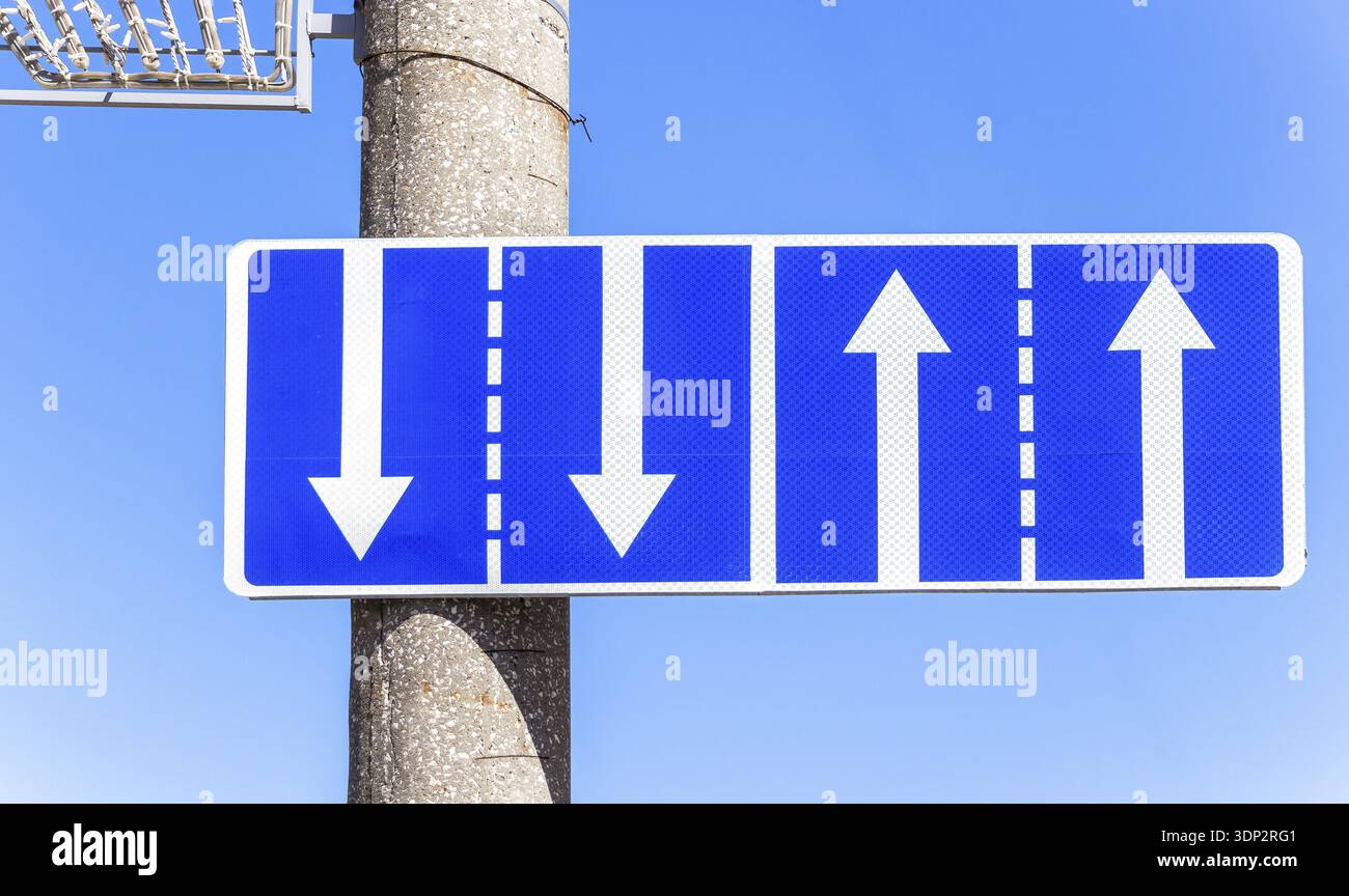 Traffic sign pointing multiple road lanes direction on city street ...