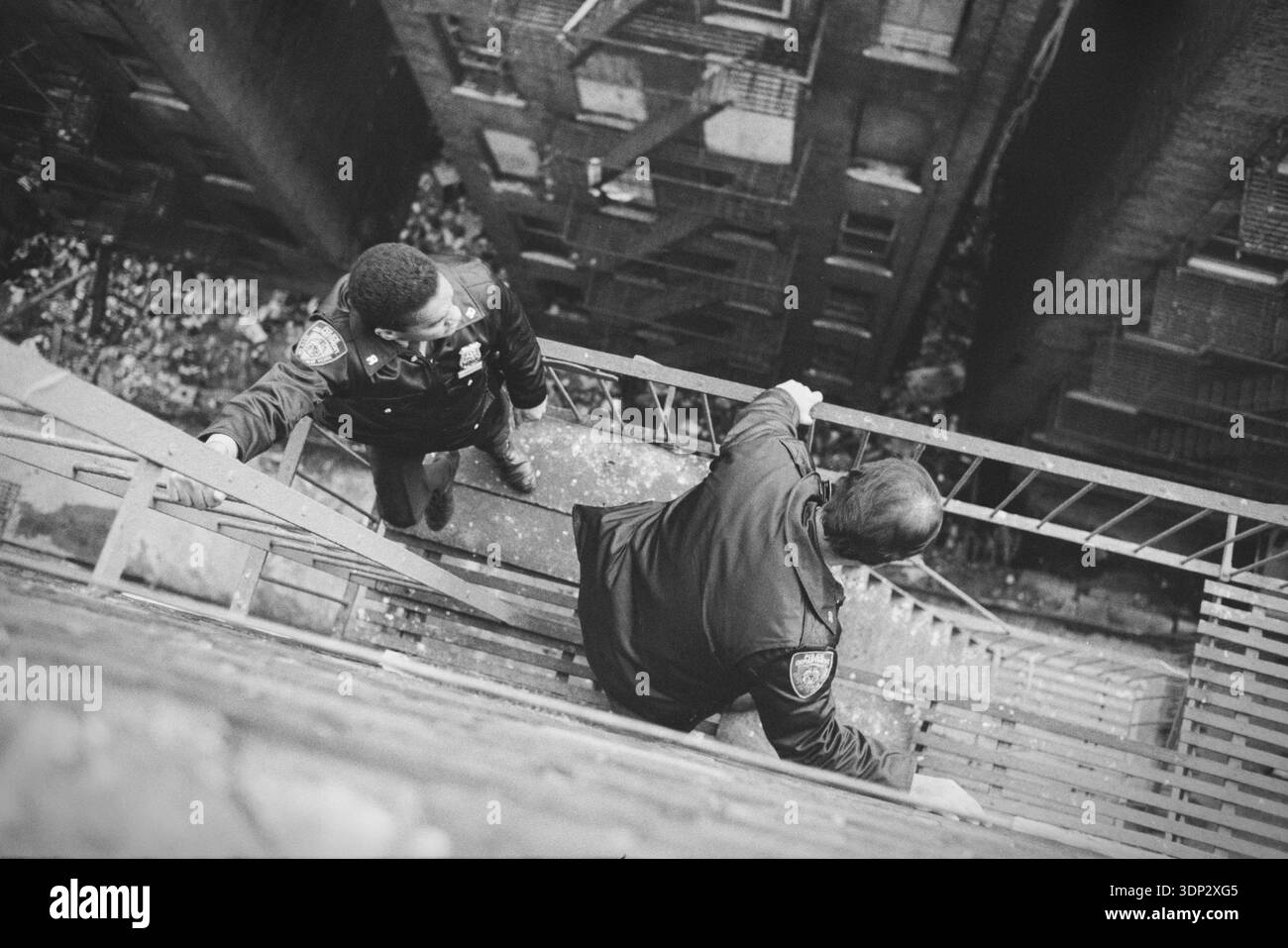 Two New York City police officers conduct a search from a steep fire ...