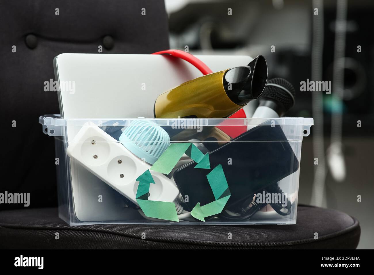 Container with electronic waste for recycling on chair in warehouse ...