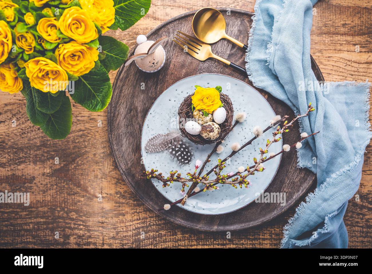 Overhead view of an Easter place setting with Easter eggs and flowers Stock Photo