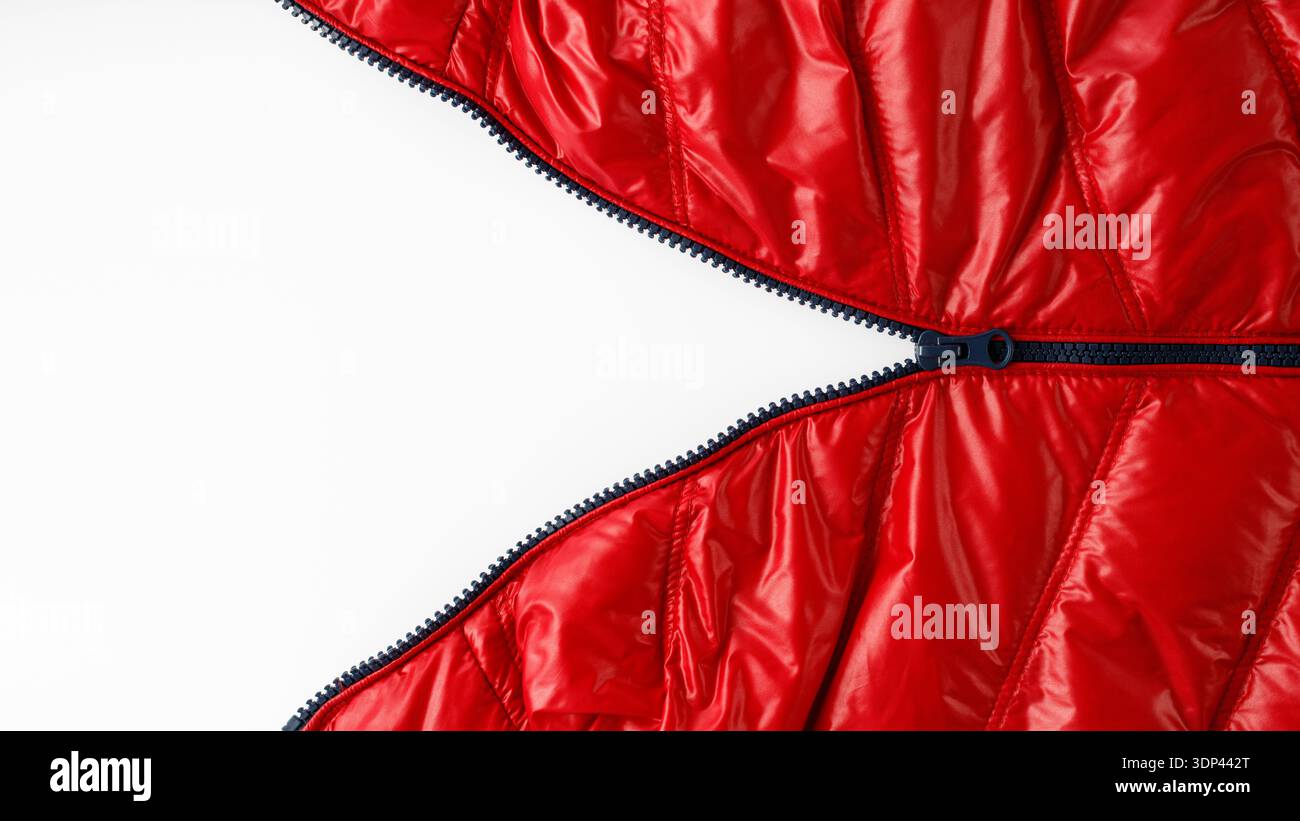 Open blue zipper on red winter down jacket on light background with copy space Stock Photo