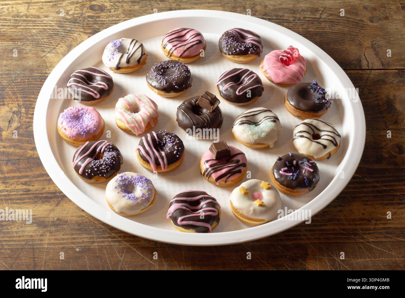 Mini donuts covered in chocolate on a white background. Stock Photo