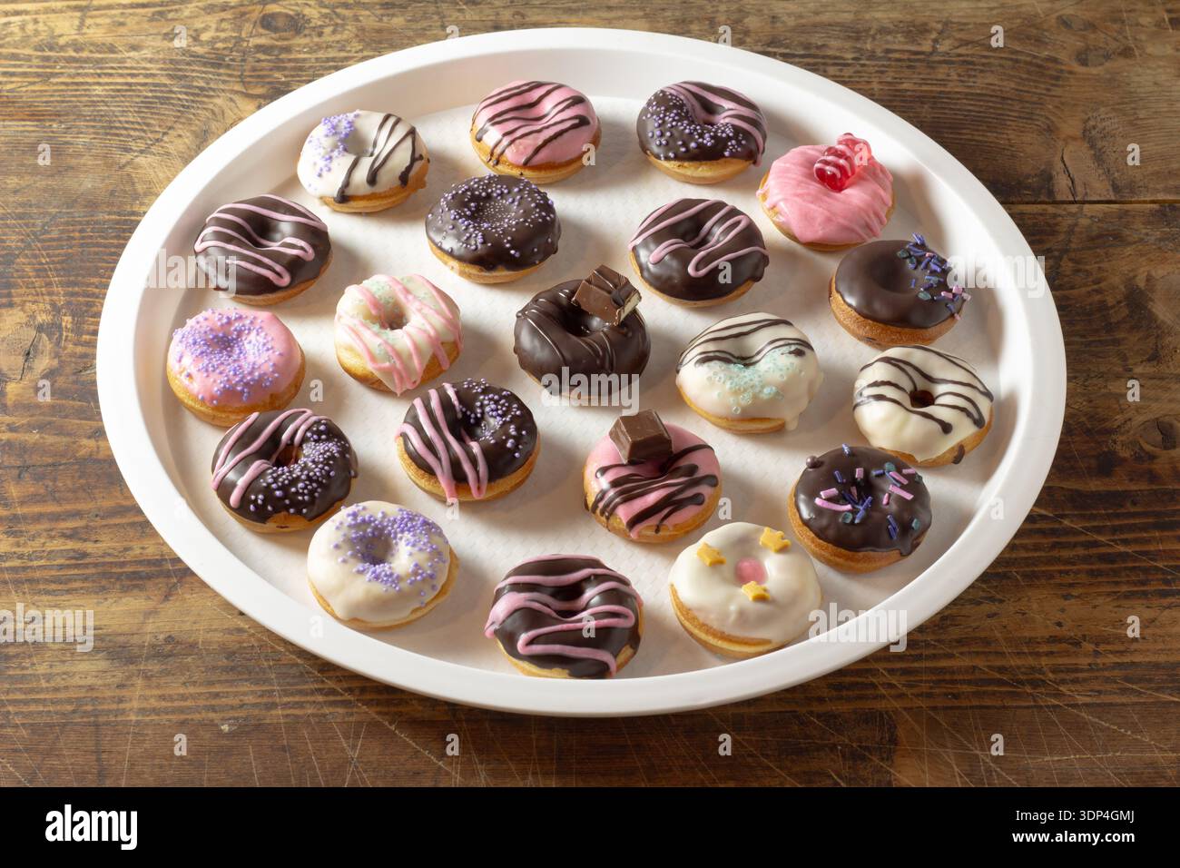 Mini donuts covered in chocolate on a white background. Stock Photo