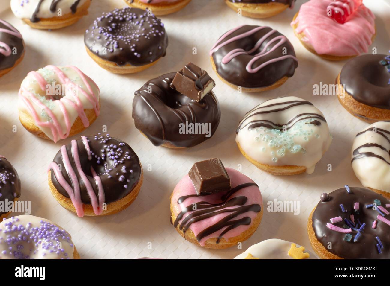 Mini donuts covered in chocolate on a white background. Close-up Stock Photo