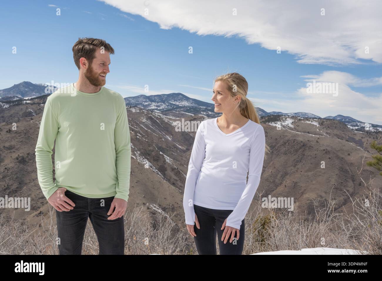 Active couple smiling together on a winter mountain summit Stock Photo