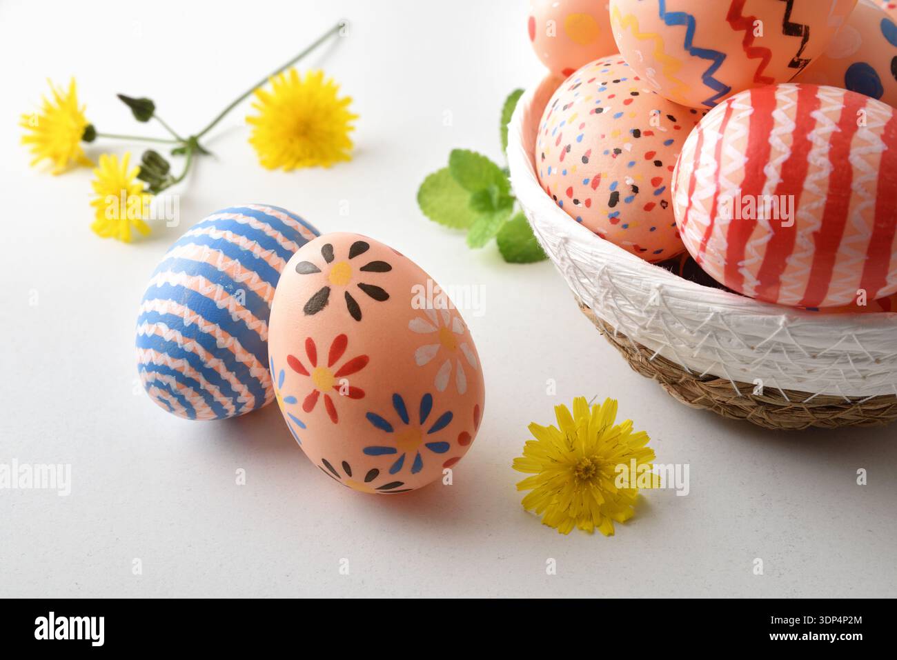 Colorful Easter Eggs in Basket with Flowers Stock Photo