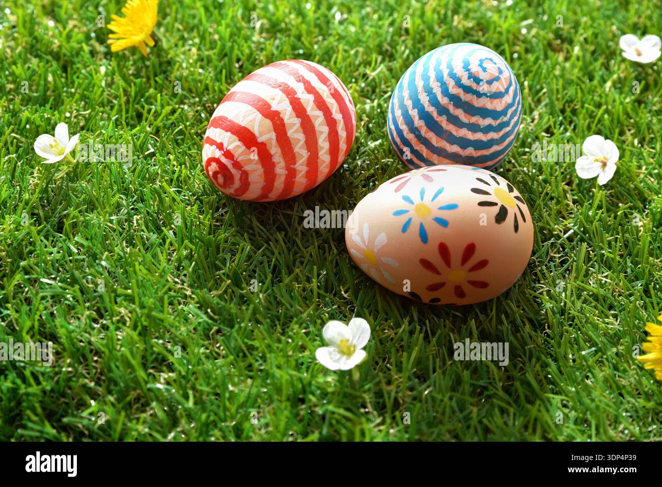Three Painted Easter Eggs on Green Grass Stock Photo