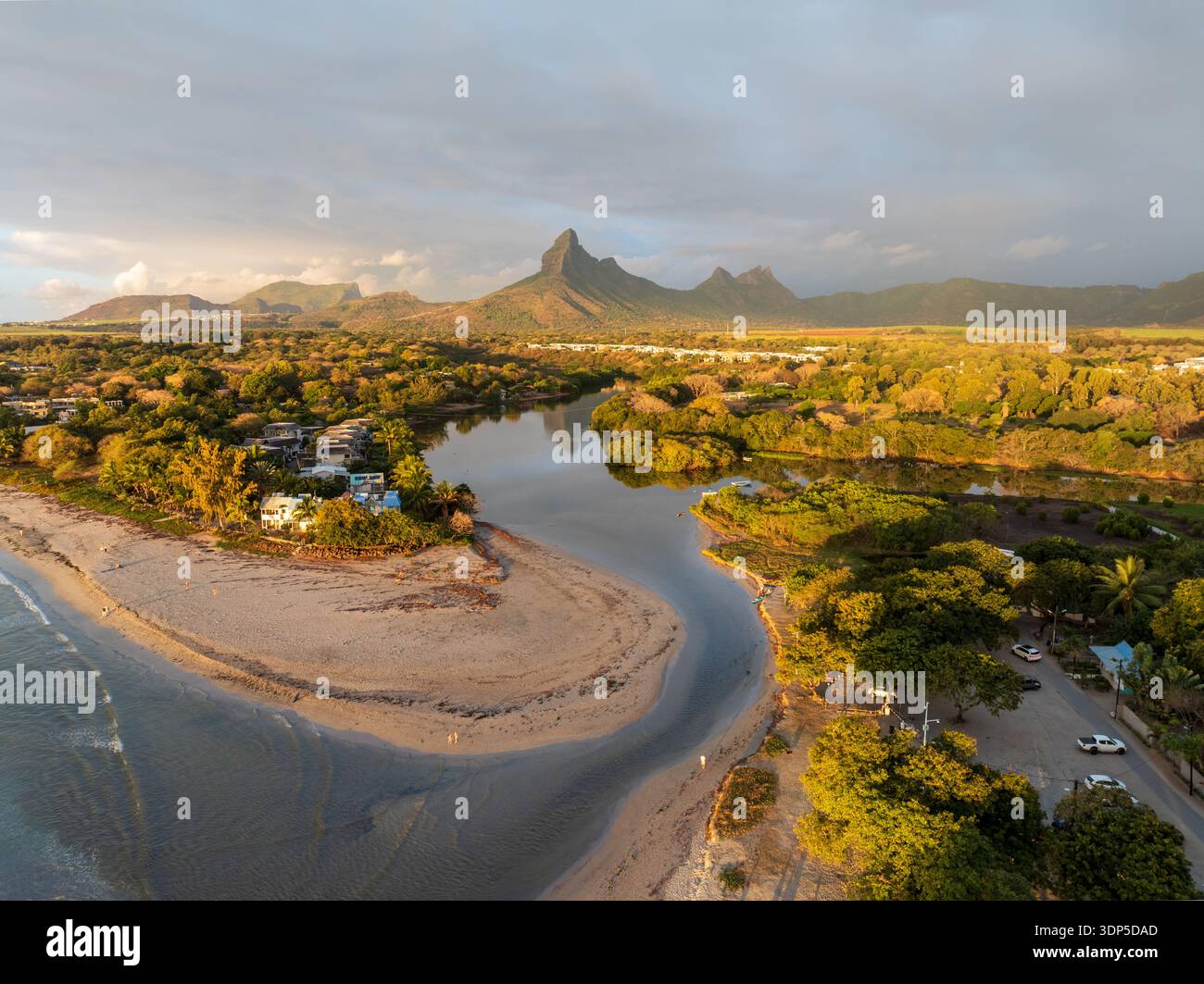 Aerial view of a river mouth meeting the sea under a cloudy sky, with ...