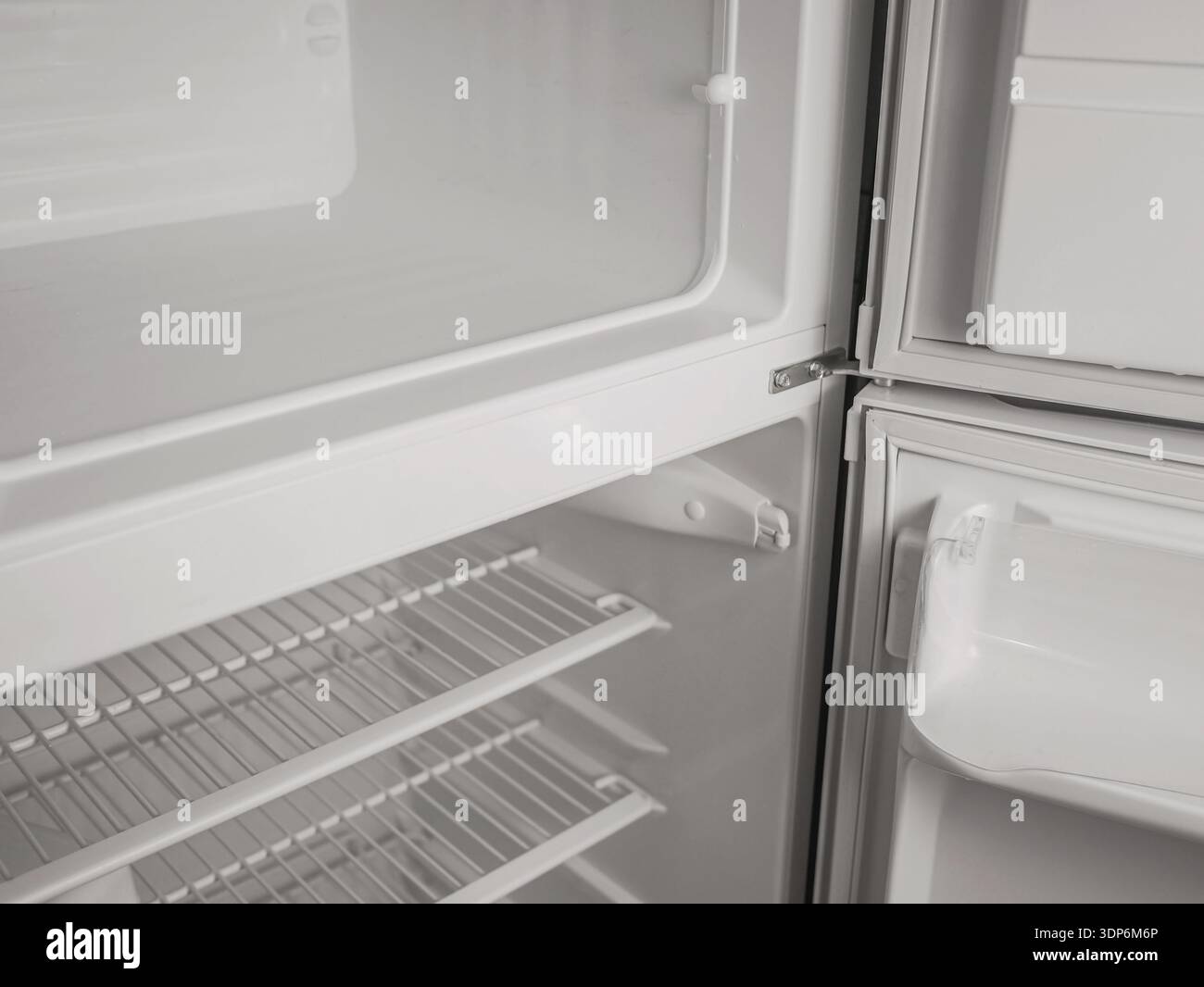 Empty Freerzer Empty refrigerator and freezer interior with open door, white shelves ...