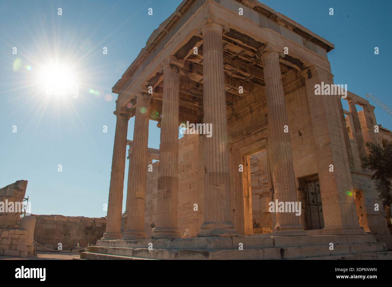 Ancient Greek temple with Ionic columns bathed in golden sunlight at ...