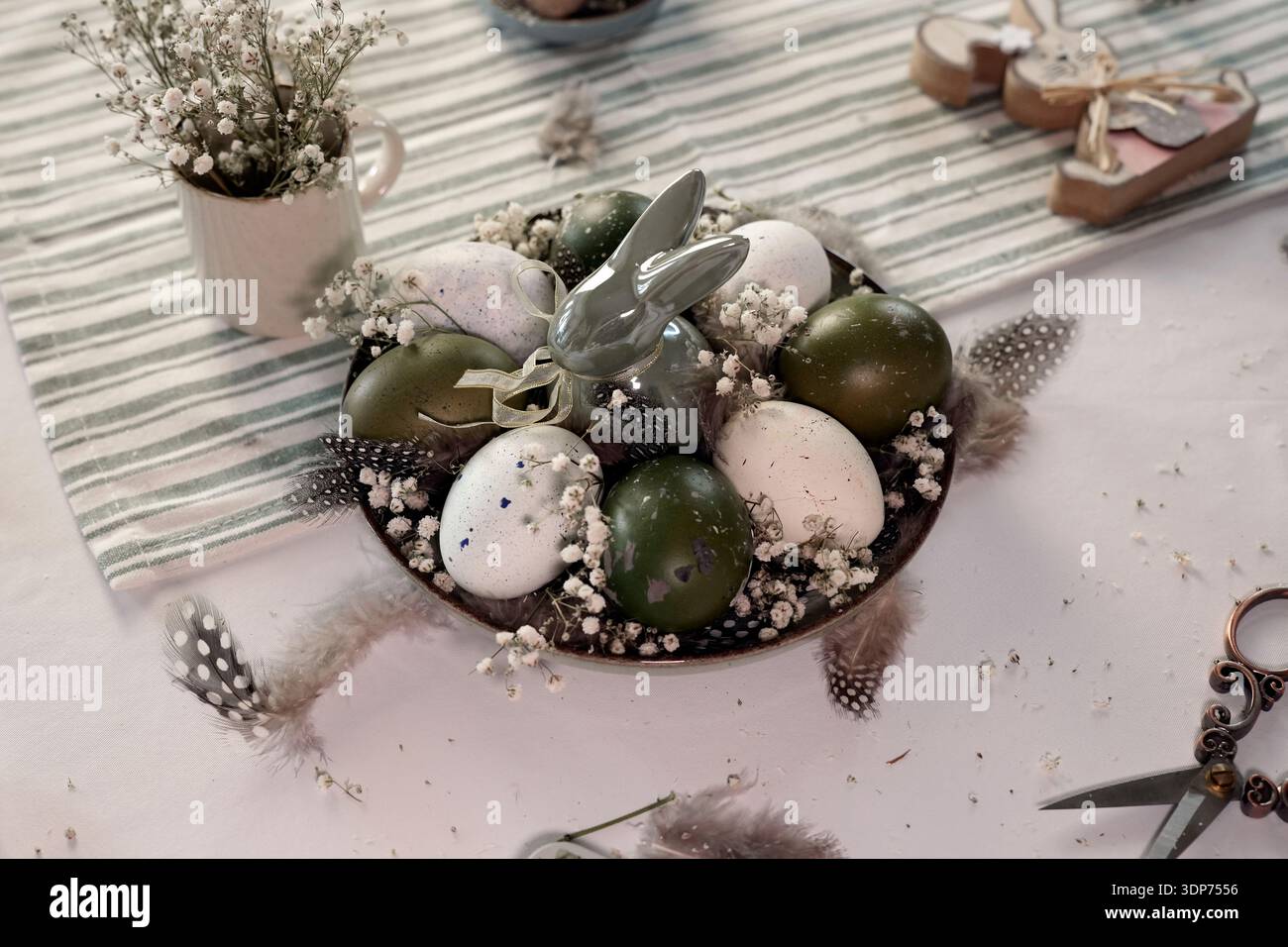 Rustic Easter still life with olive eggs and decor. Stock Photo