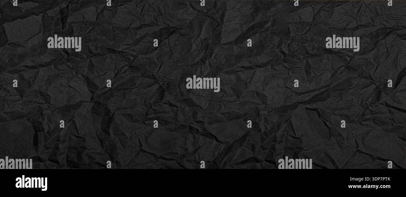 Black crumpled paper background showing intricate wrinkles and a rough textured surface Stock Photo